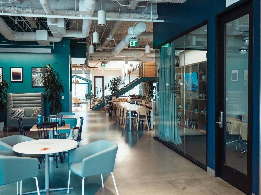 Open and collaborative modern office space with stylish furniture and natural lighting.